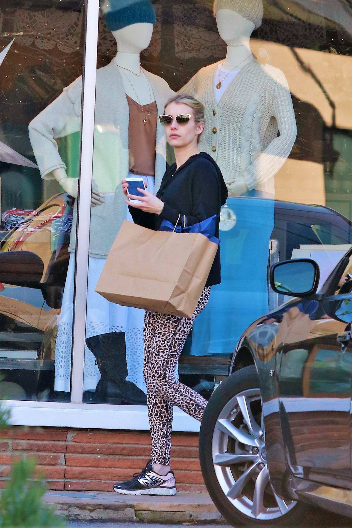 Emma Roberts seen wearing a black jacket and animal print leggings while  out shopping in Studio