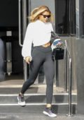 Sofia Richie wears a white cropped sweatshirt and black leggings while shopping at XIV Karats Store in Beverly Hills, California