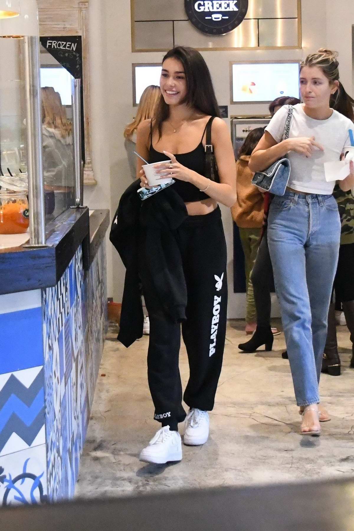 Madison Beer sports grey sweatshirt and white leggings during a