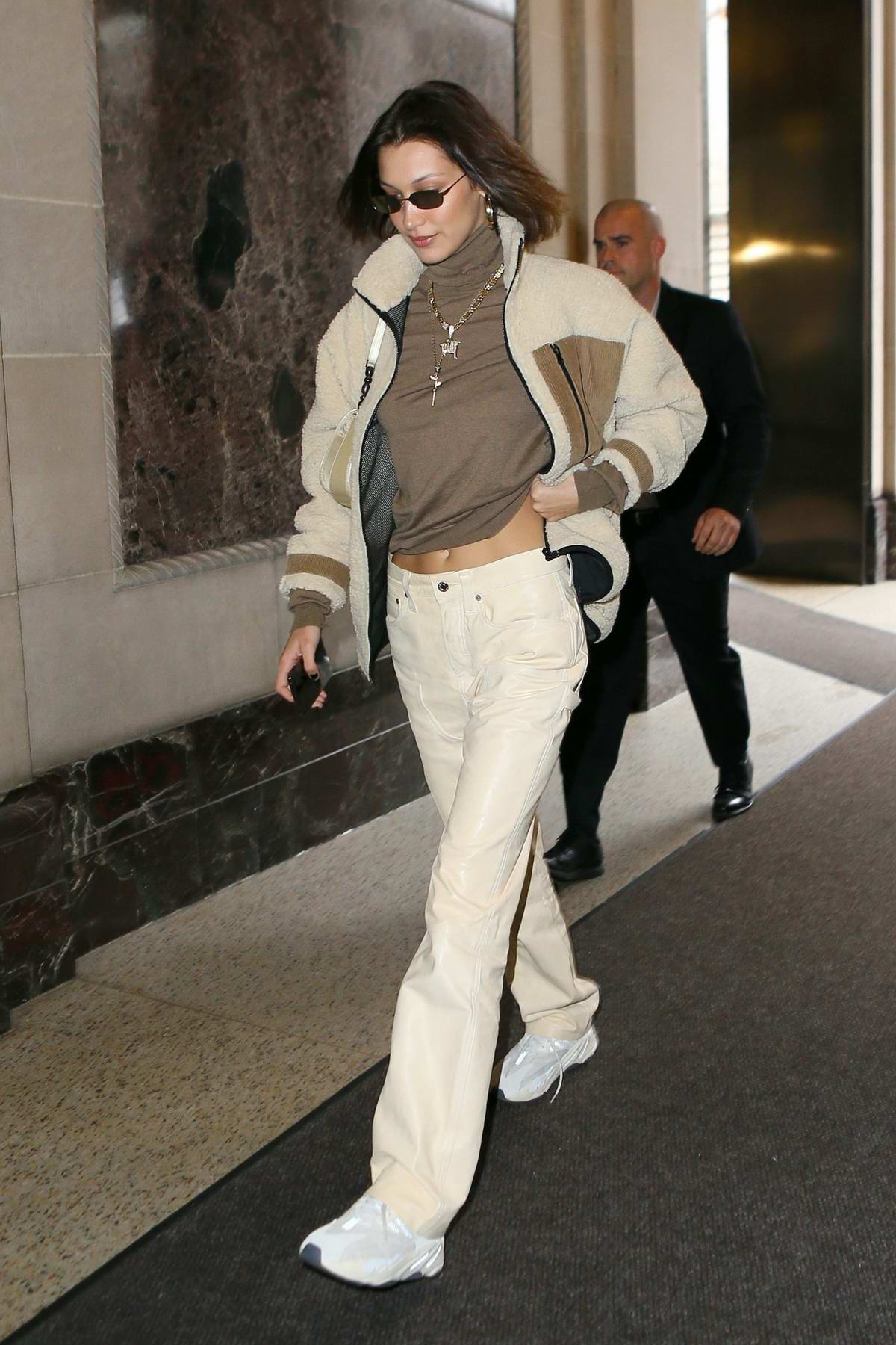 bella hadid looks trendy in a jacket over her brown top and khakis ...