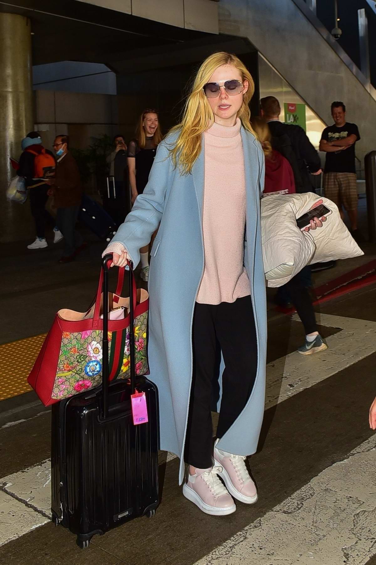 Elle Fanning carries a colorful Gucci bag as she touches down at