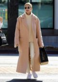 Hailey Bieber wears a beige long coat and Nike Air Force 1s as she steps out in Los Angeles