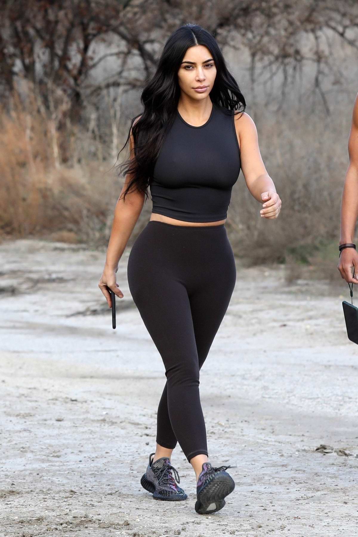 Kim Kardashian sports a black crop top and leggings as she steps