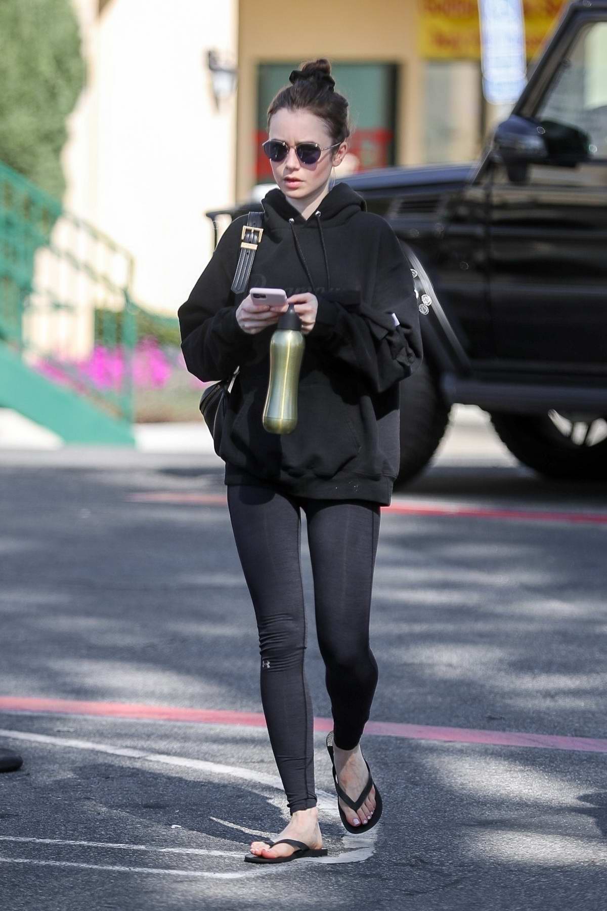 Lily Collins sports a black hoodie and leggings as she wraps up a hot ...