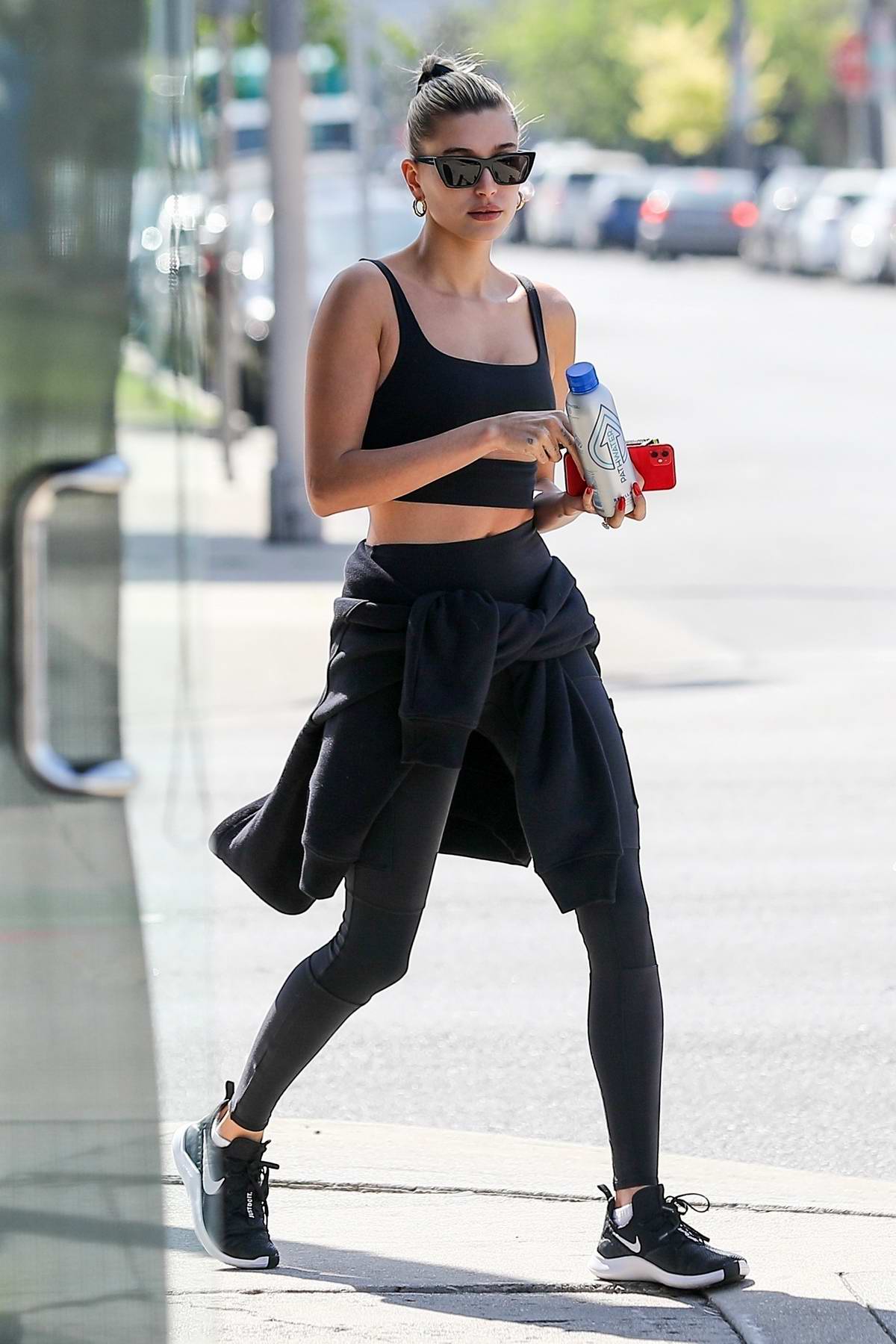hailey bieber sports a black workout top and leggings during a lunch ...