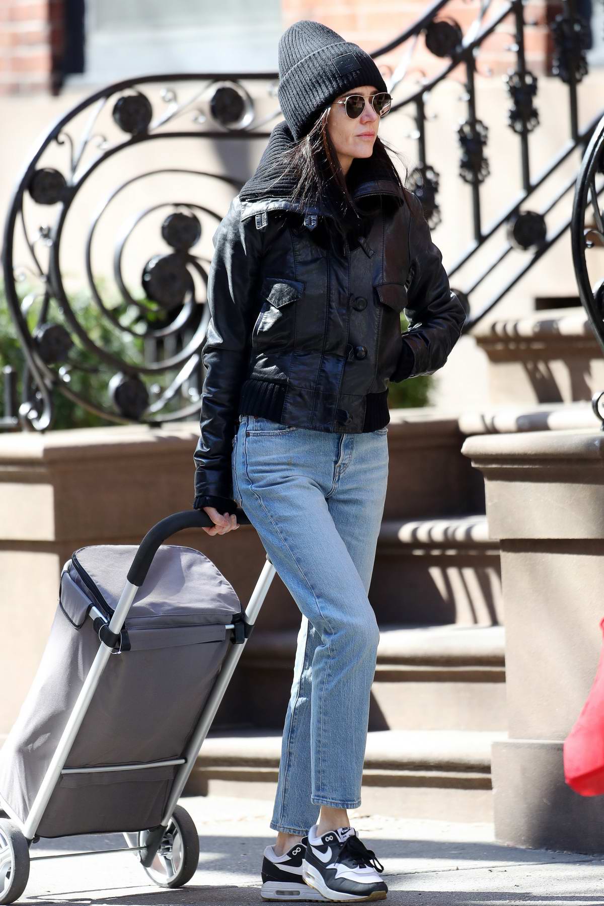 jennifer connelly bundles up in a black beanie, matching jacket, jeans, and  nike trainer while out in new york city-100320_4