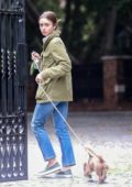 Lily Collins braves the light rain and takes her pooch for a stroll in Beverly Hills, California