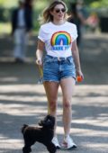 Ashley James looks trendy in denim shorts and a NHS tee while out to walk her dog at a local park in London, UK