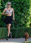 Devon Windsor sports a crop top and bike shorts while out for a run in Miami, Florida