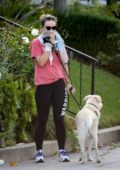 Olivia Wilde covers her face with a shirt while out for a stroll with her dog in Los Angeles