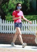 Aubrey Plaza wears a pink top and blue shorts as she steps out to walk her dogs in Los Angeles