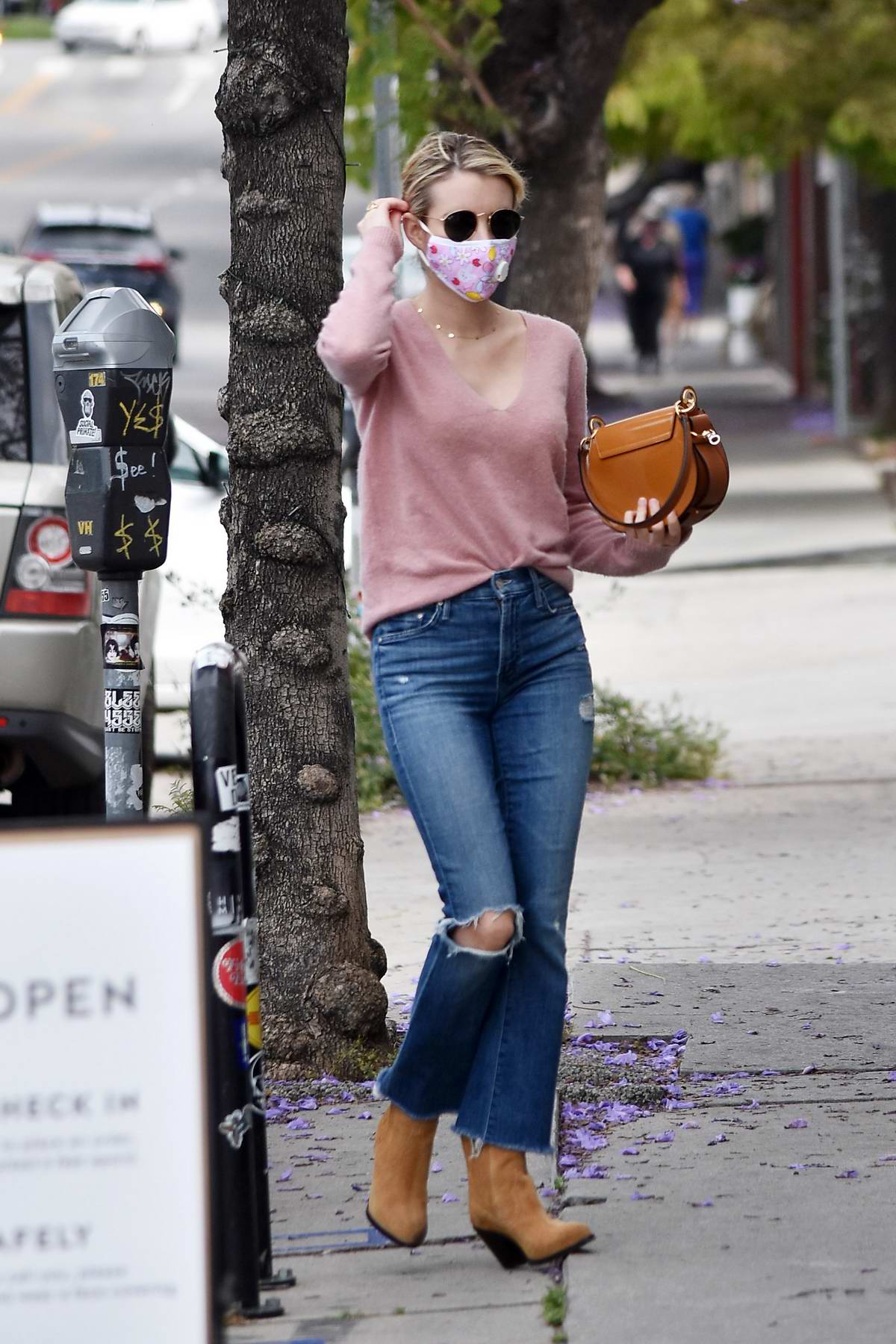 Emma Roberts looks trendy in a pink sweater, ripped jeans and suede boots  during a coffee