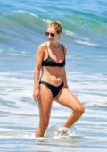 Rosie Huntington-Whiteley shows off her beach body in a black bikini as she hits the ocean in Malibu, California
