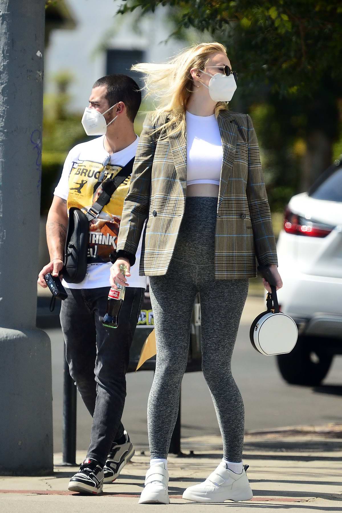 Sophie Turner shows off her growing baby bump in a crop top and leggings  while out