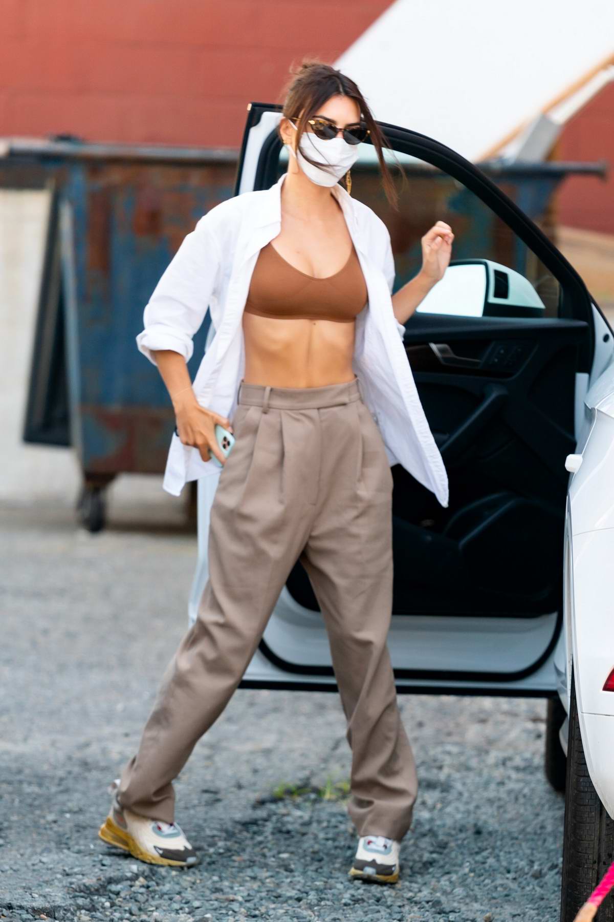 Emily Ratajkowski rocks a white shirt over a sports bra while heading out  with a friend