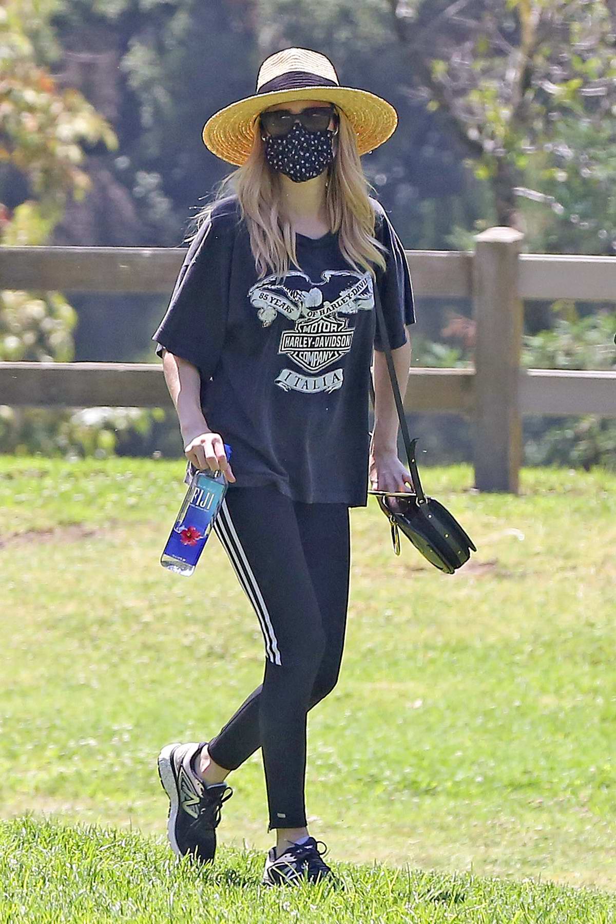 Emma Roberts wears a vintage Harley-Davidson tee and leggings with a fedora  while making a
