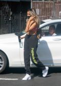 Madison Beer wears a pink sports bra and black sweatpants as she
