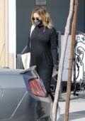 Ashley Tisdale shows her baby bump in a black maxi dress while shopping in West Hollywood, California