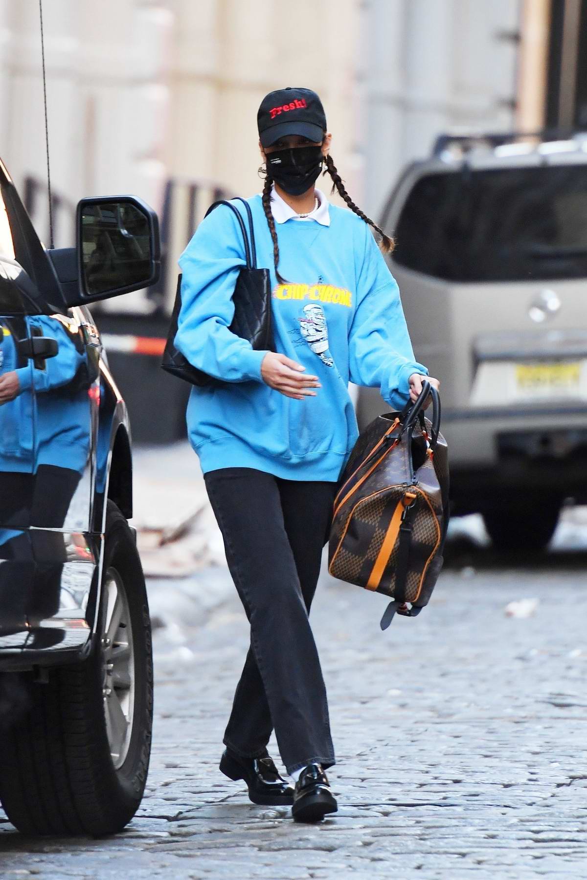 bella hadid carries her louis vuitton and chanel bags as she steps