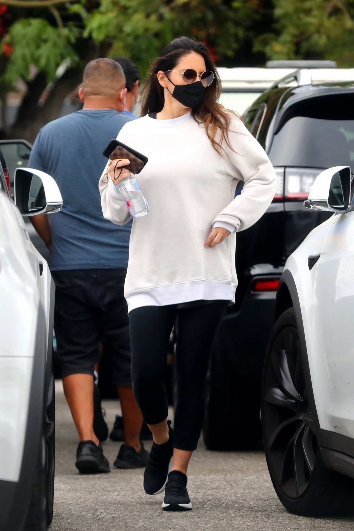 Olivia Munn sports an oversized white sweatshirt and black leggings as she  leaves her gym after