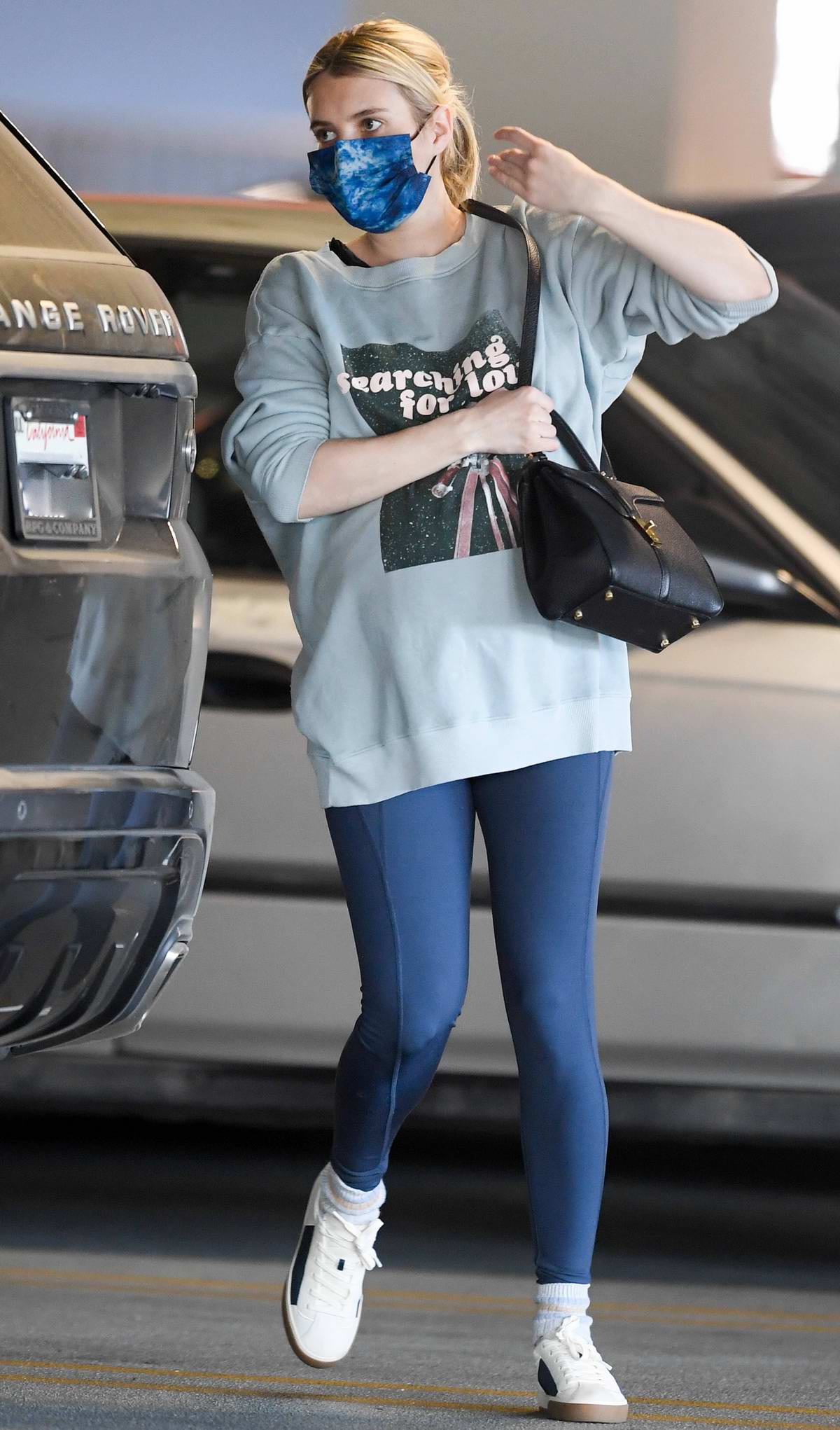 Actress Emma Roberts wears an all-black outfit consisting of a  star-patterned sweater, hoodie and jeans paired with white sneakers as she  arrives at LAX after a flight from Atlanta, GA. Roberts, who