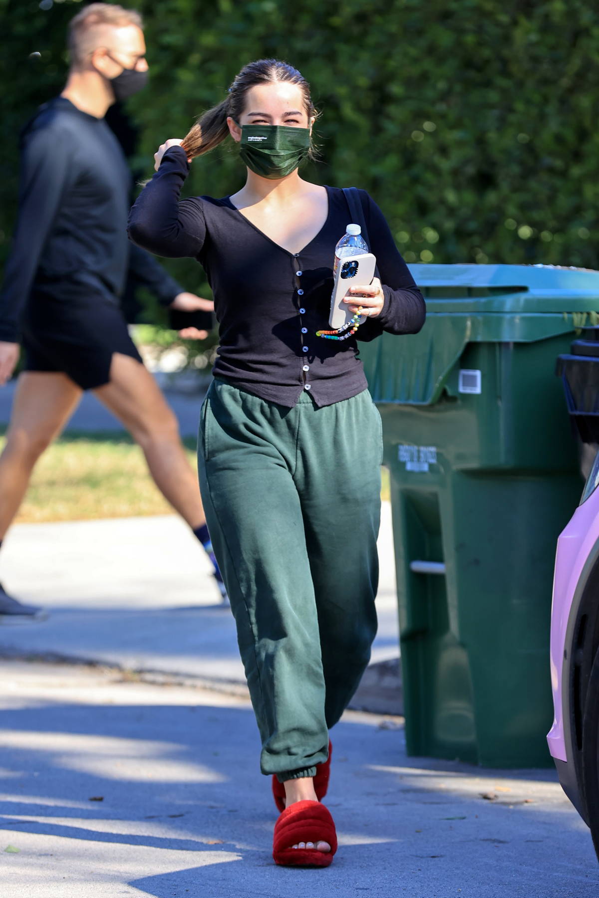 addison rae looks comfy in a black top, green sweatpants and red