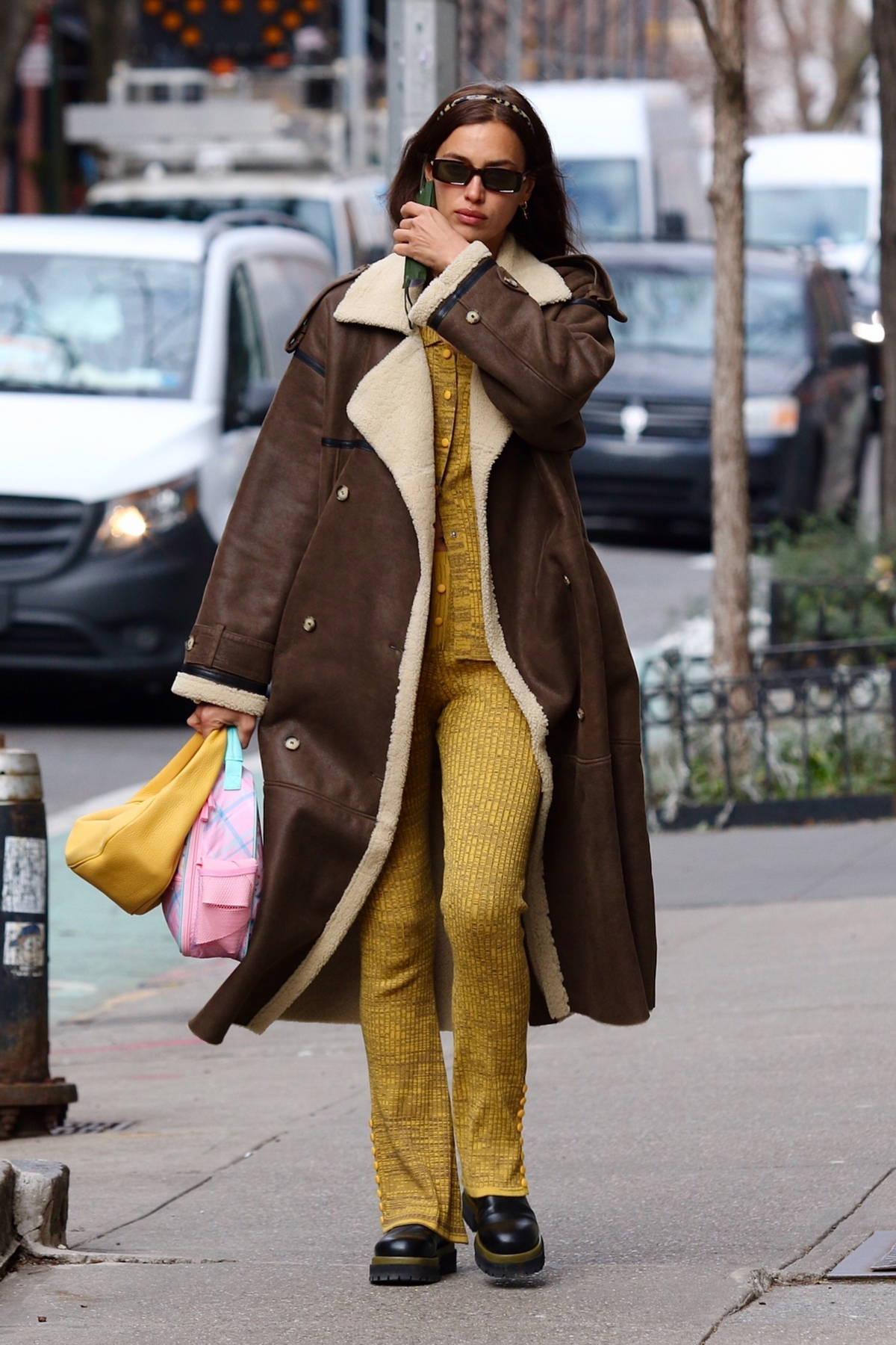 irina shayk looks fashionable in a long brown coat with a yellow outfit ...