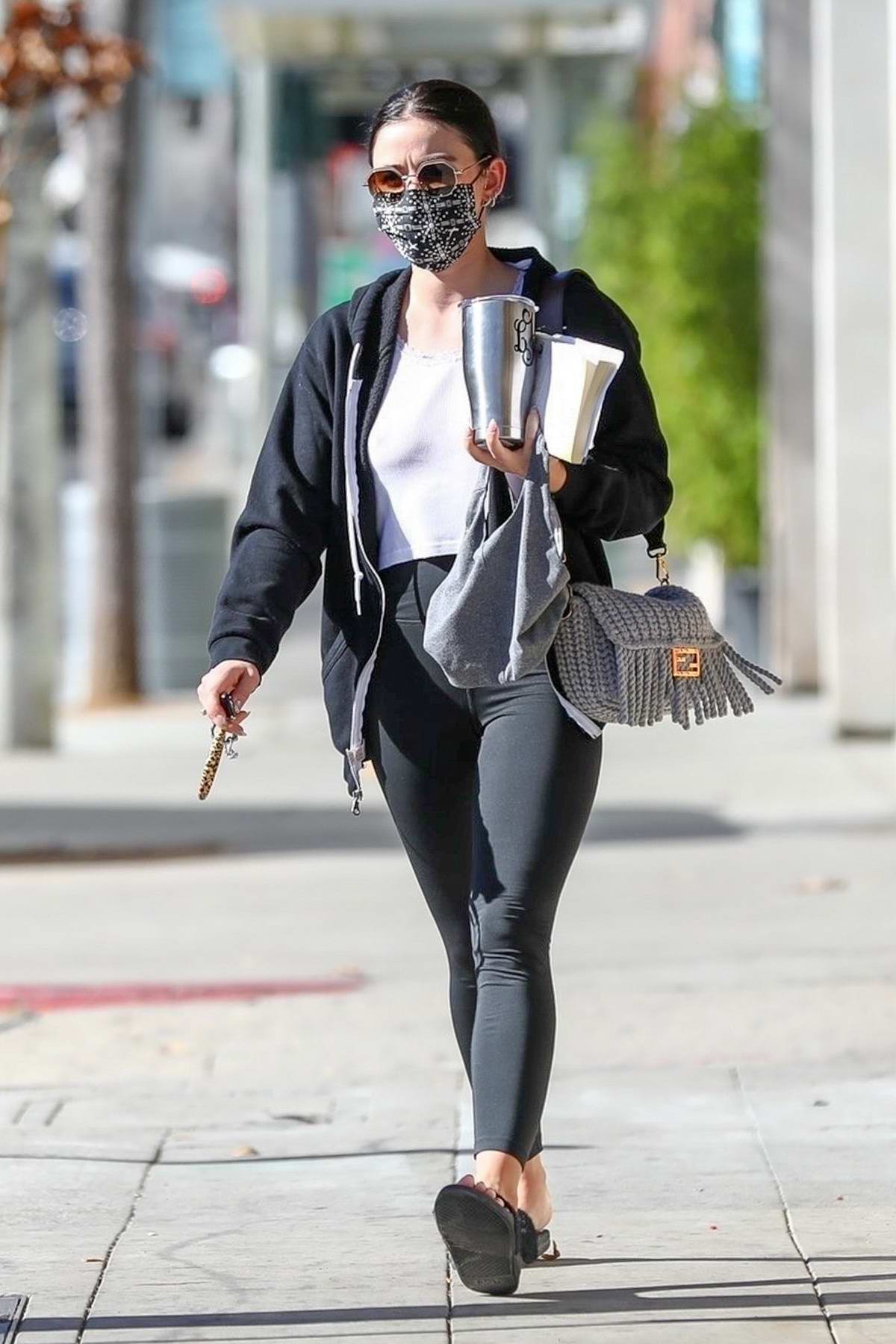 Lucy Hale sports a white crop top and black leggings while heading for a  workout session