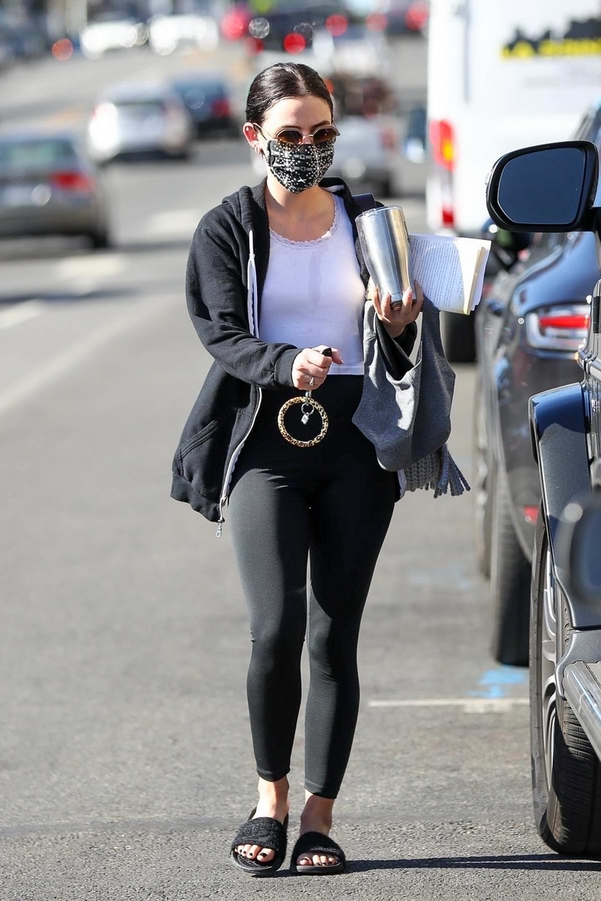 Lucy Hale sports a white crop top and black leggings while heading for a  workout session