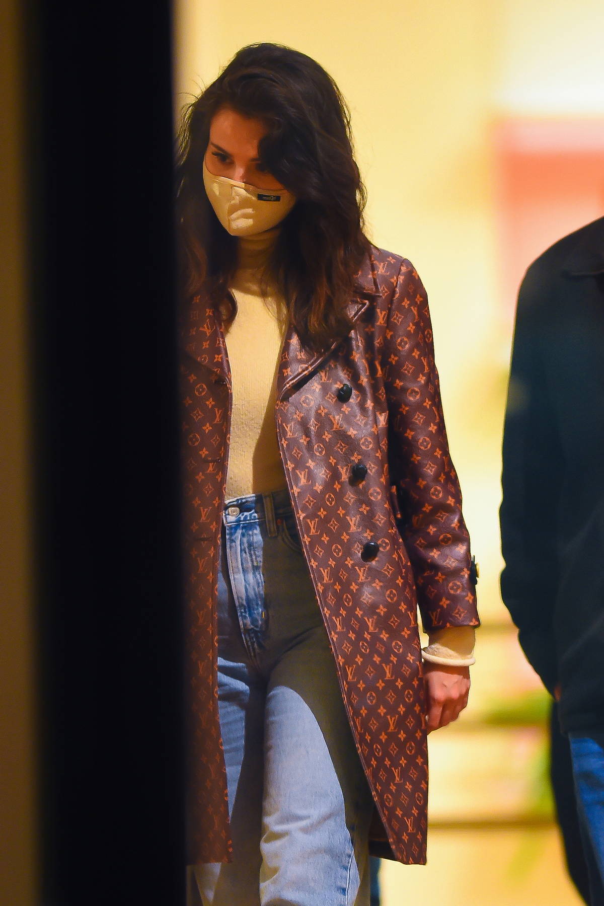 Selena Gomez rocks a beige turtleneck with a Louis Vuitton trench