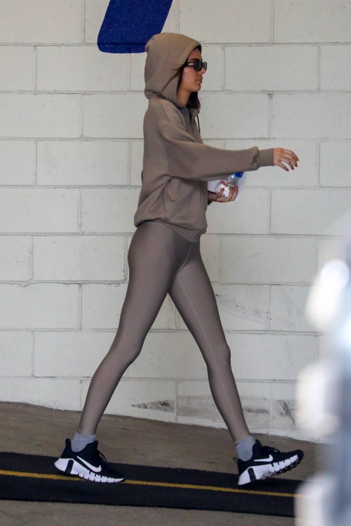 WHAT SHE WORE: Kendall Jenner in grey top black leggings and white sneakers  going to the gym March 18