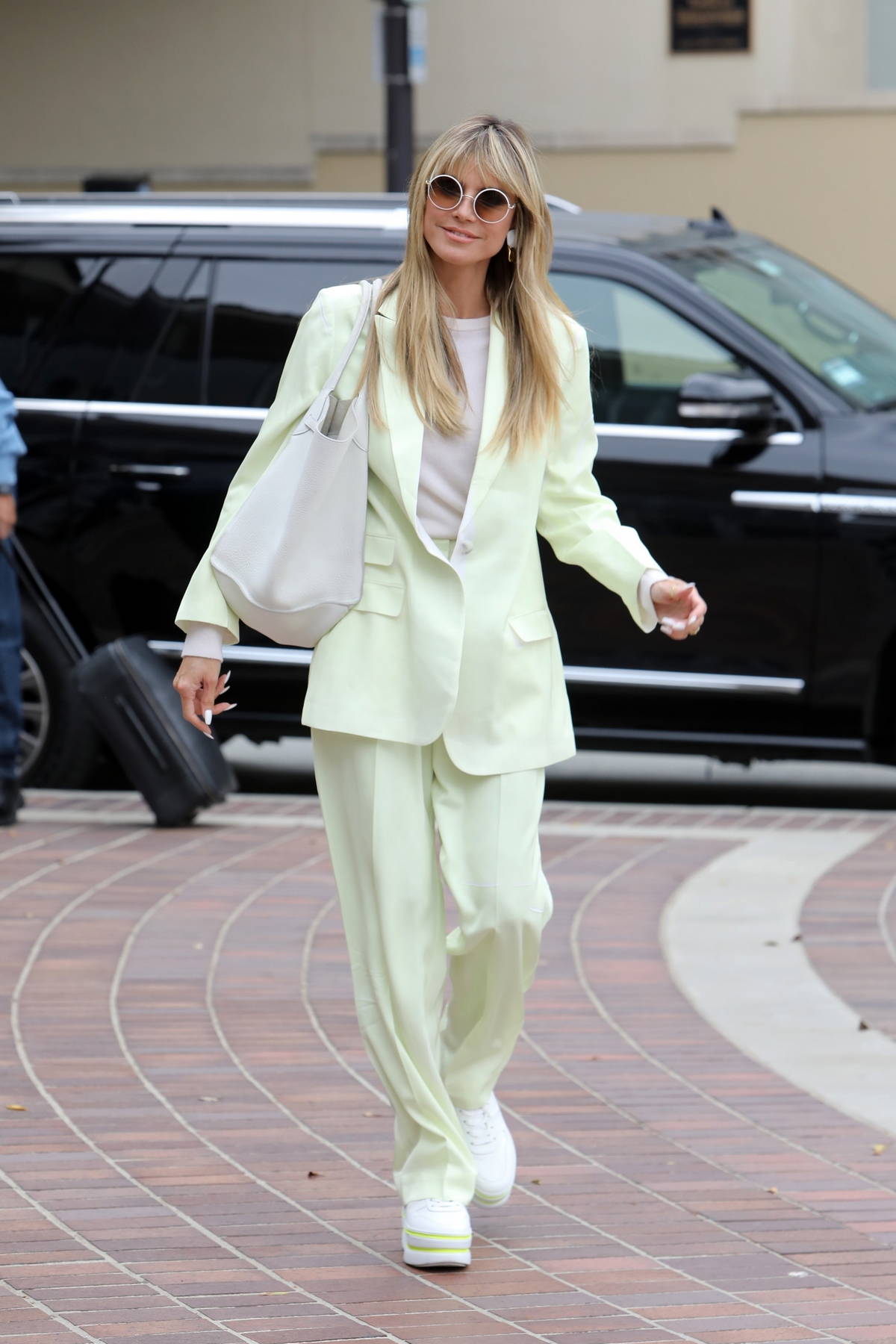 Heidi Klum dons a pastel green suit with matching sneakers as she