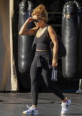 Rita Ora looks fit in a black crop top and leggings as she leaves