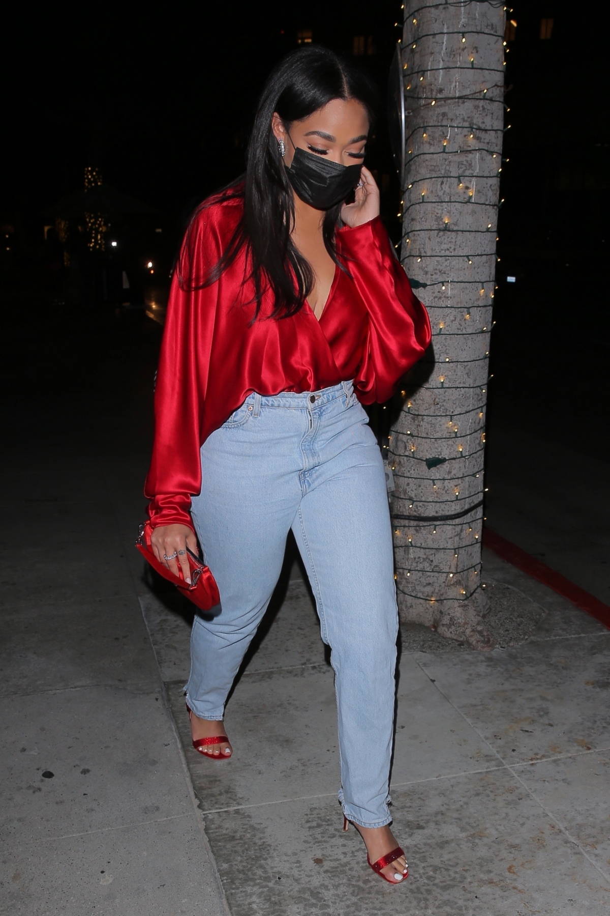 jordyn woods cuts a casual figure rocks a silk red top with jeans