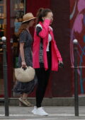 lily collins seen wearing a pink jacket and black leggings while