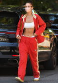 Bella Hadid flaunts her washboard abs in a crop top and red track suit during a lunch outing in the West Village, New York City