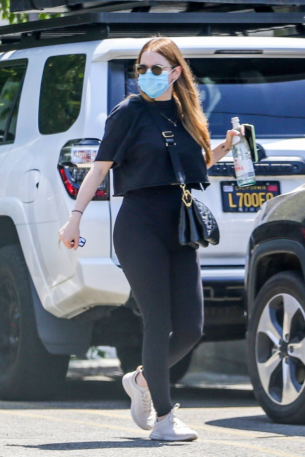Emma Stone dons a cropped black t-shirt and leggings while heading