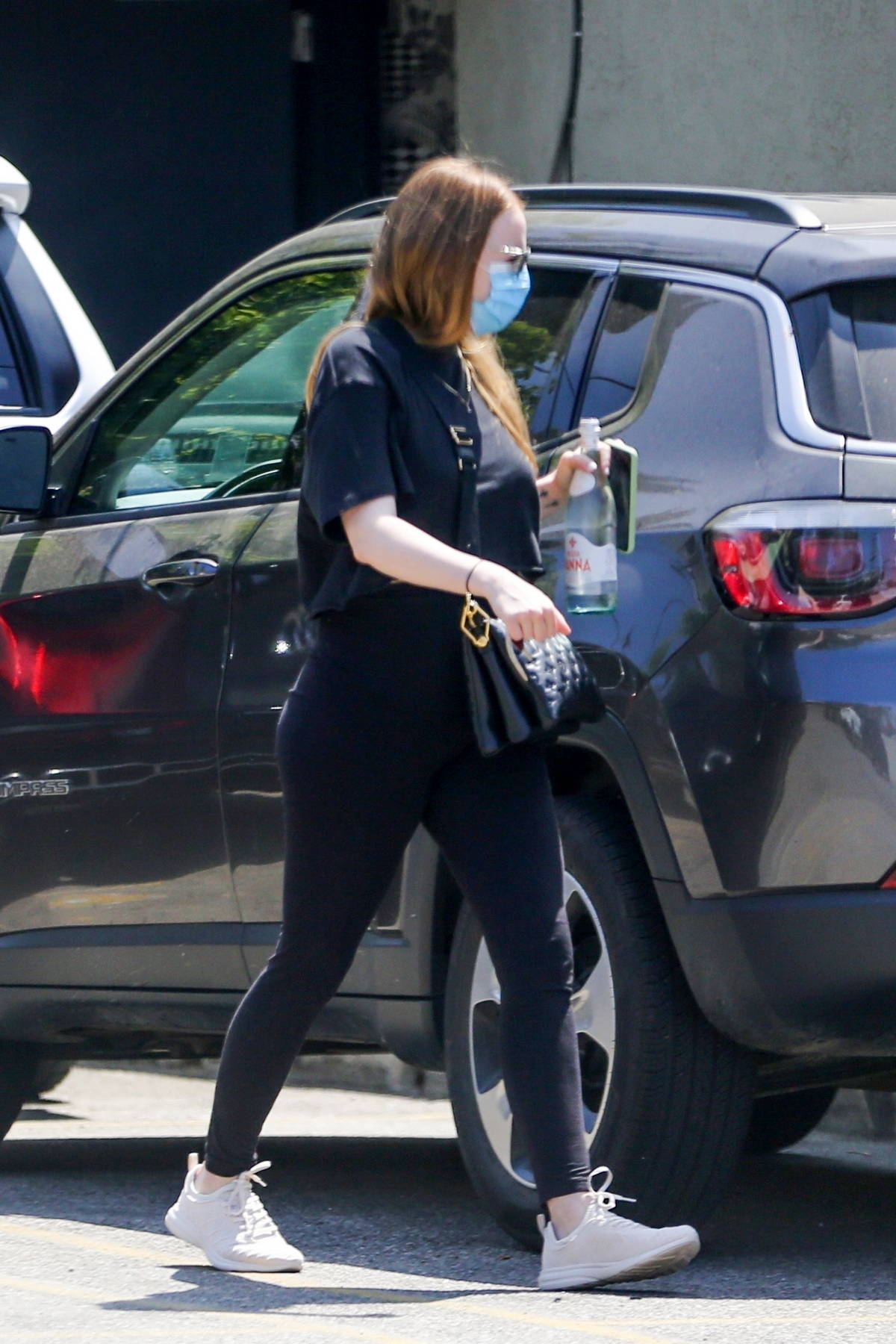 Emma Stone dons a cropped black t-shirt and leggings while heading