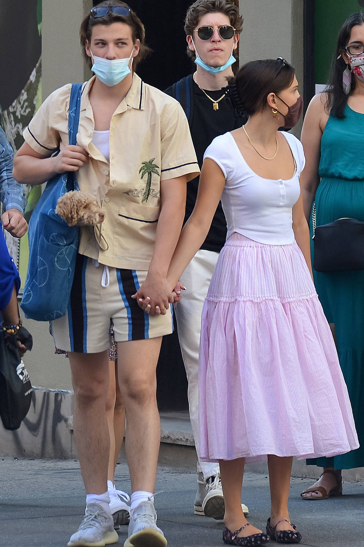 millie bobby brown and boyfriend jake bongiovi hold hands as they step