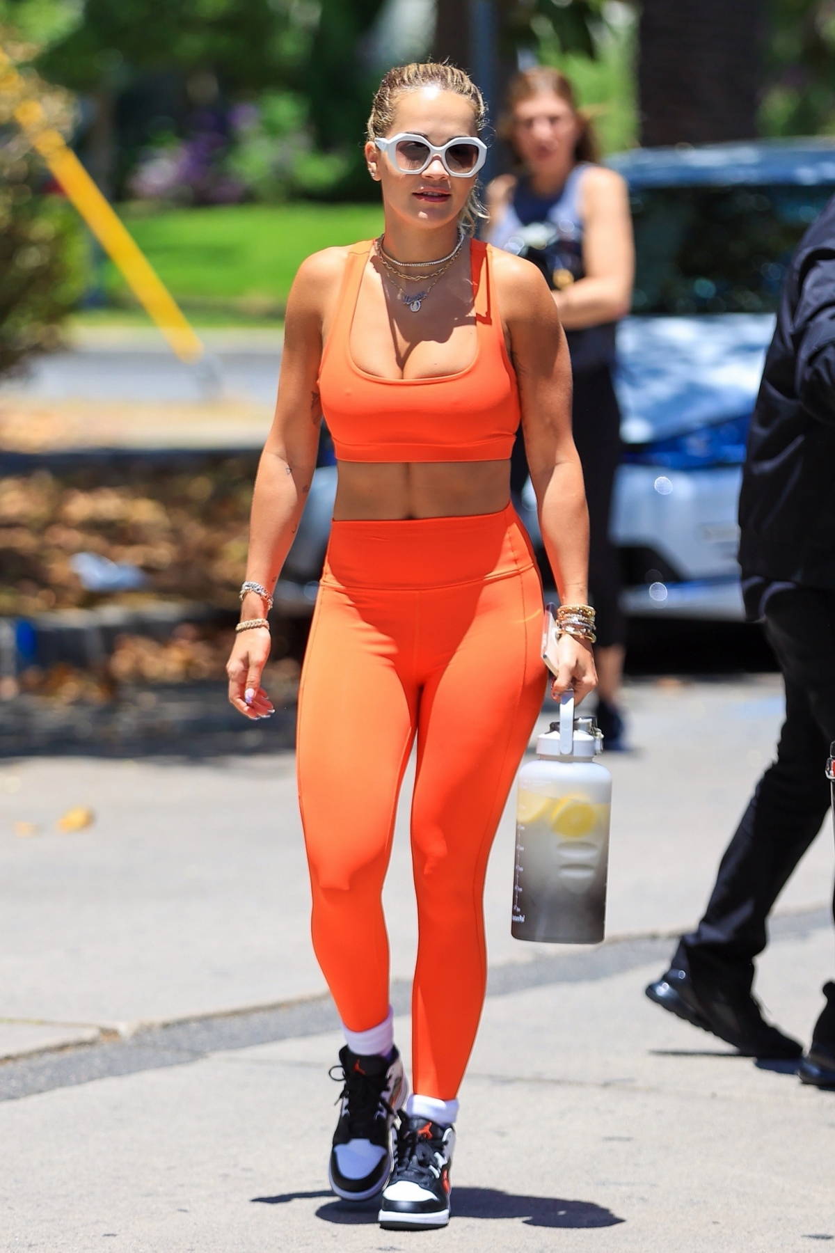 Rita Ora shows off her toned physique in a bright orange outfit