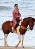 Alessandra Ambrosio looks stunning in a red bikini while enjoying horseback riding on the beach in Trancoso, Brazil