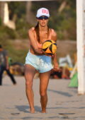 Alessandra Ambrosio showcases her beach body in a sports bra and shorts  during a beach volleyball