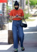 Camila Mendes goes casual in an orange Adidas tee and jeans while stepping out in Los Angeles