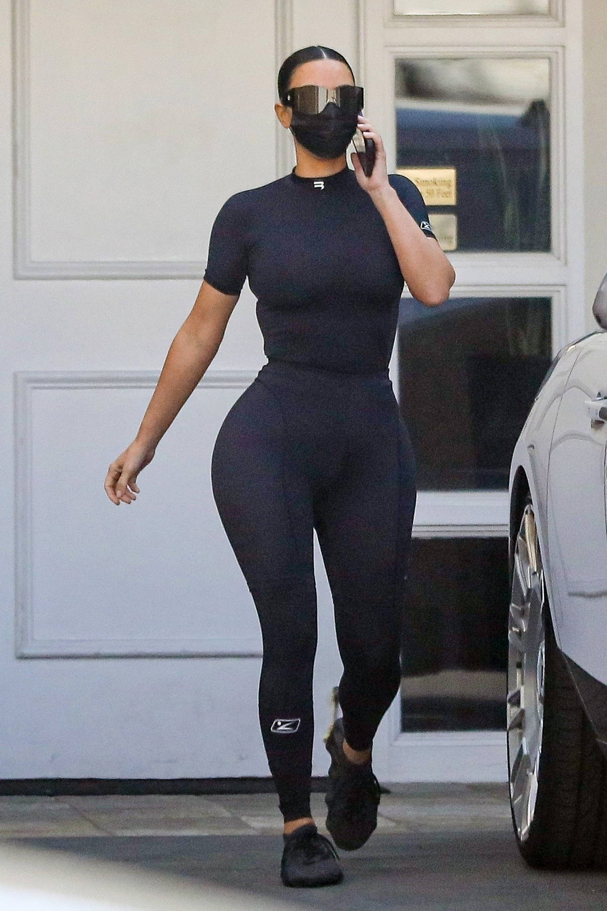 Kim Kardashian flaunts her curves in form-fitting black top and leggings as  she leaves Epione