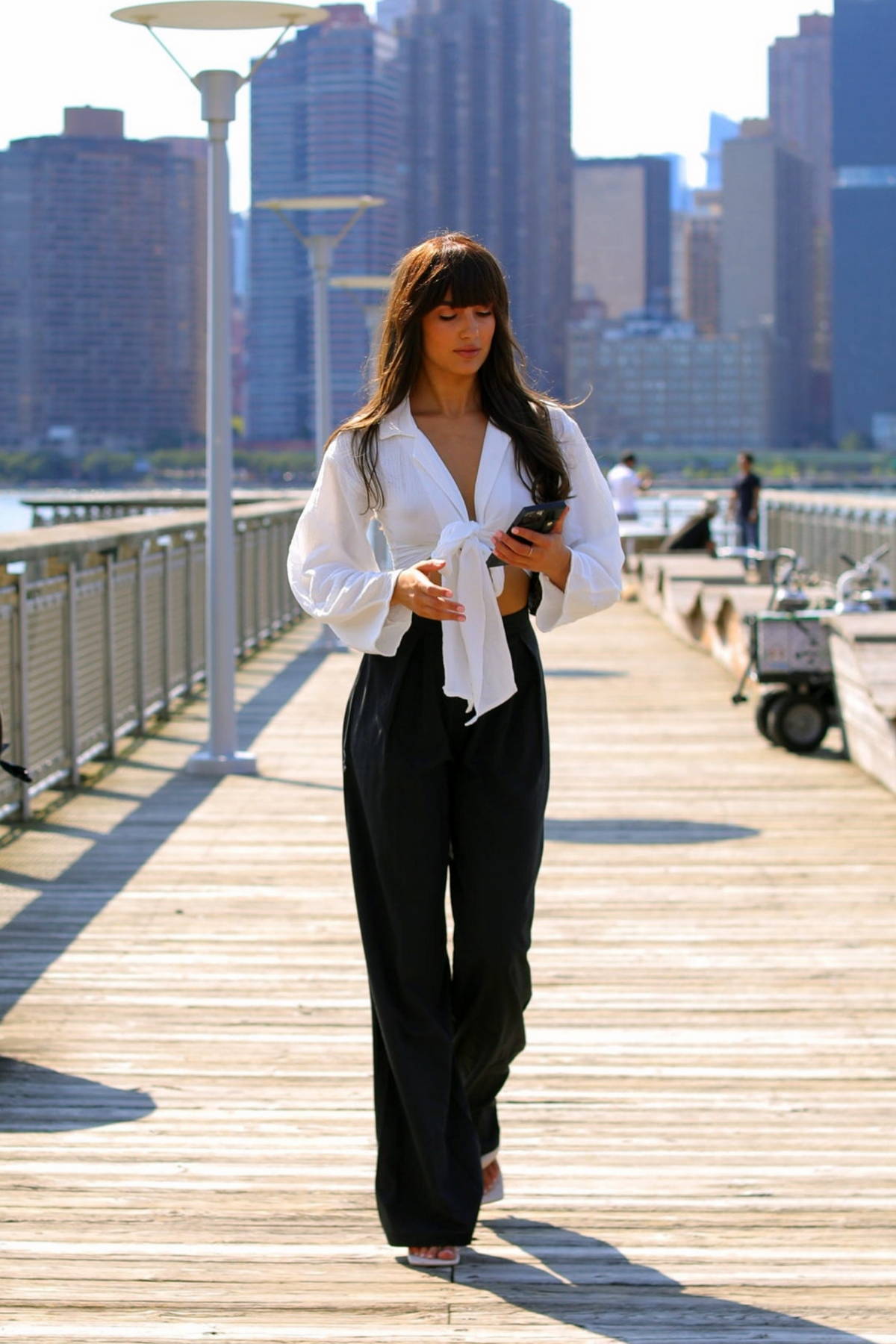 Young business woman on the street of a modern city in white blouse and black  trousers Stock Photo - Alamy