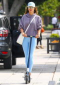 Alessandra Ambrosio sports baby blue leggings and a hoodie while out riding a scooter in Brentwood, California