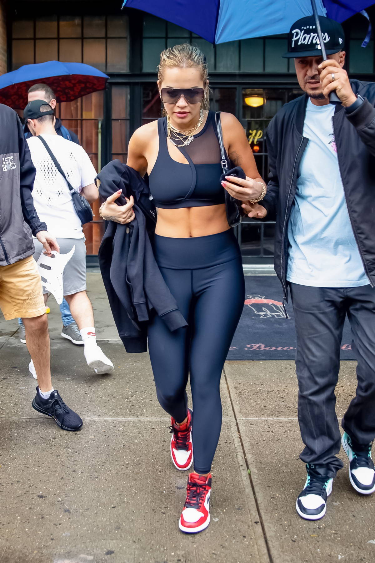 Rita Ora shows off her toned abs in a black sports bra and leggings while  heading