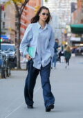 Bella Hadid looks cool in baggy pants and an oversized striped shirt as she returns to her apartment in New York City