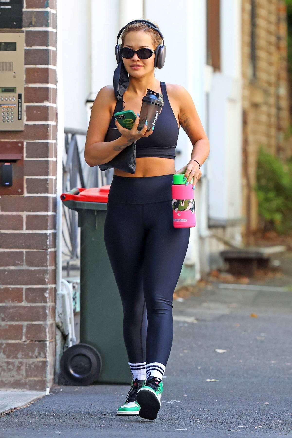 Rita Ora rocks a navy blue sports bra and leggings with Nike Dunks