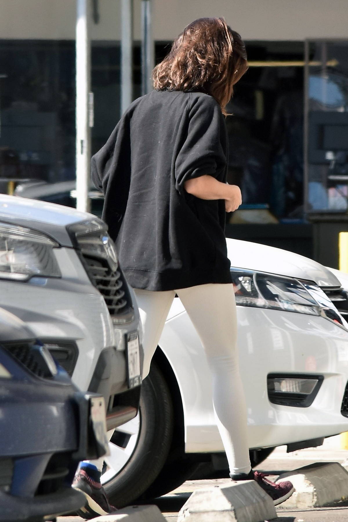 Aubrey Plaza wears a black sweatshirt and white leggings while she